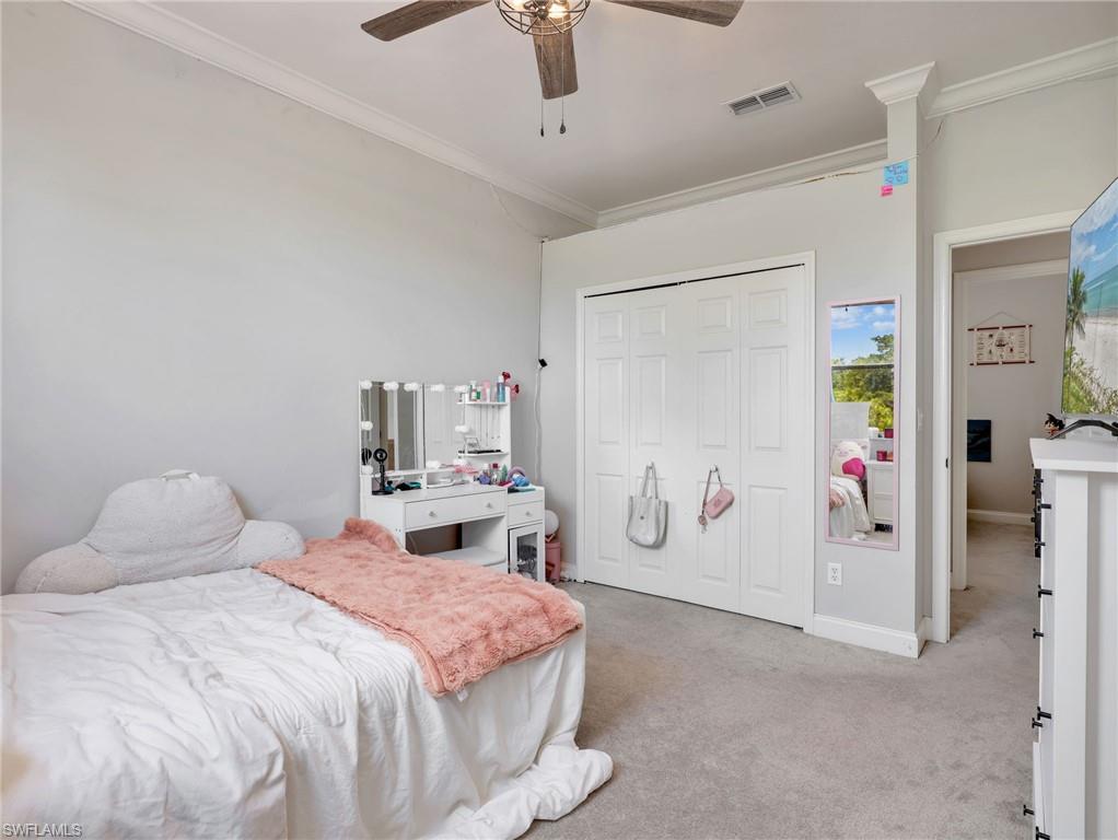Bedroom featuring light gray walls, crown molding, a ceiling fan, and carpet flooring