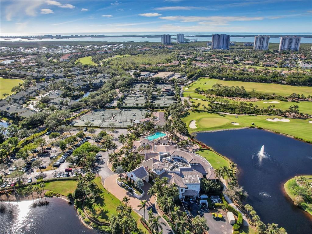 Aerial overview featuring a golf course, multiple tennis courts, and a community pool