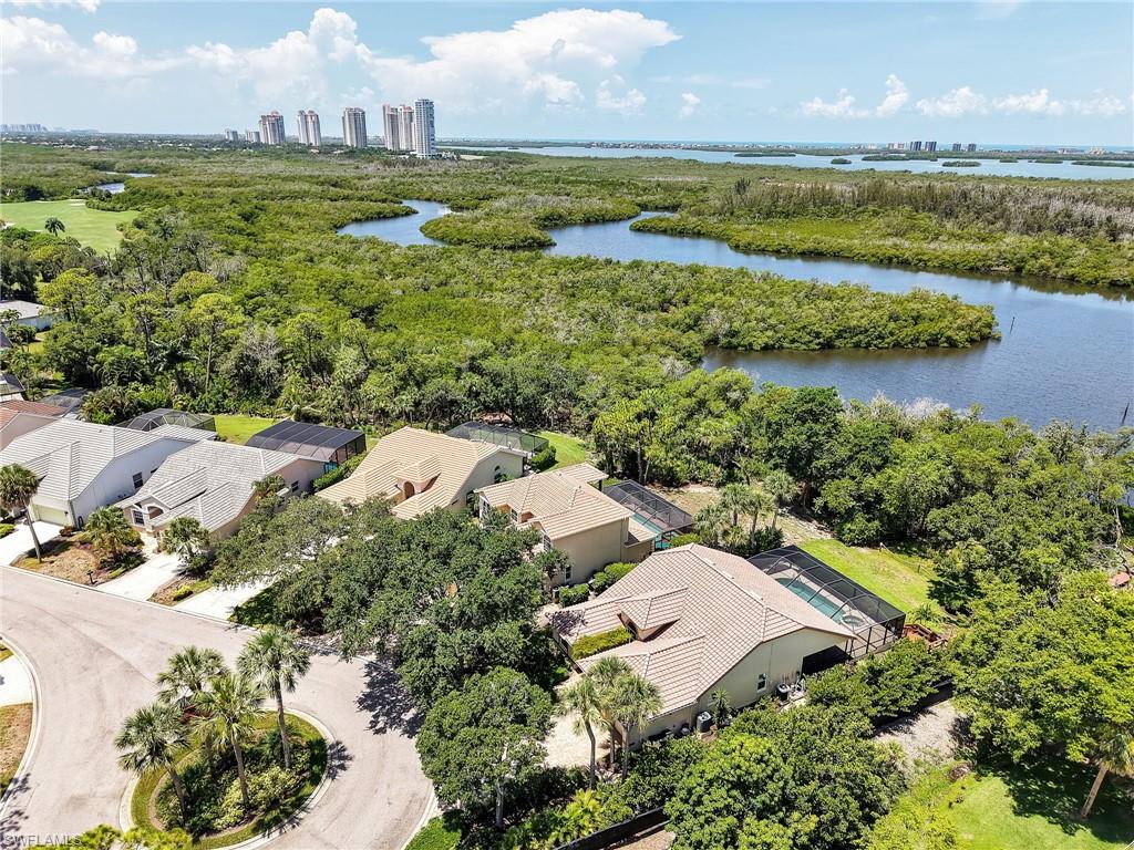 Aerial perspective showcasing a residential community bordered by a lush green preserve and waterways