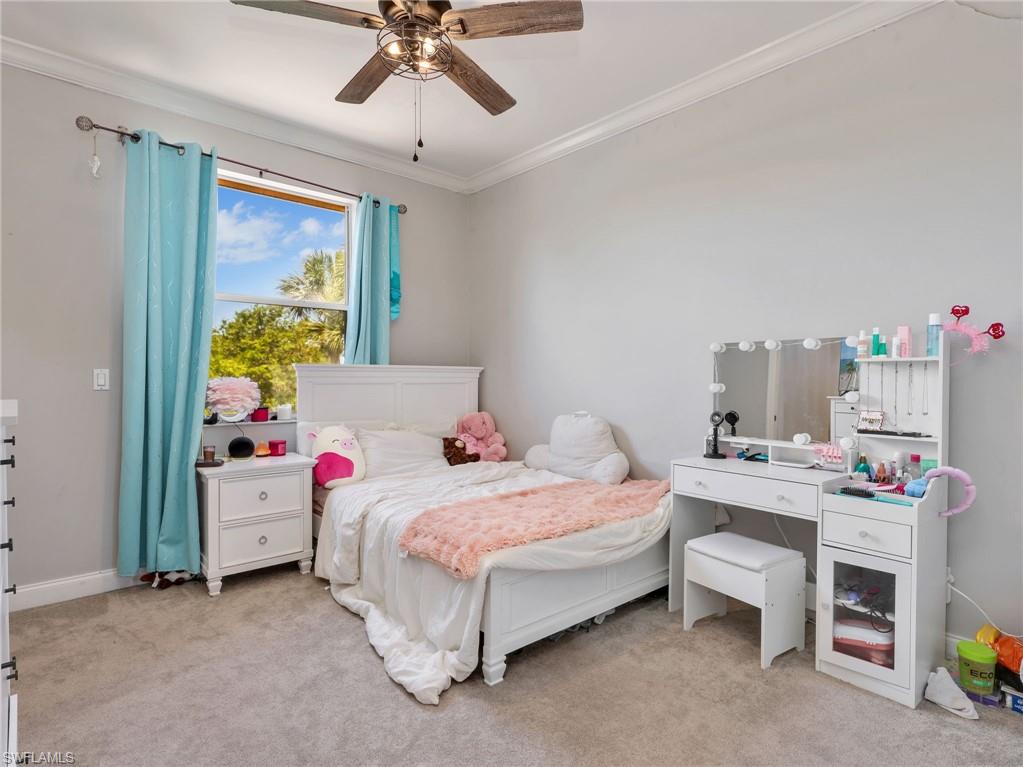 Spacious room featuring a large window, crown molding, and ceiling fan with integrated lighting