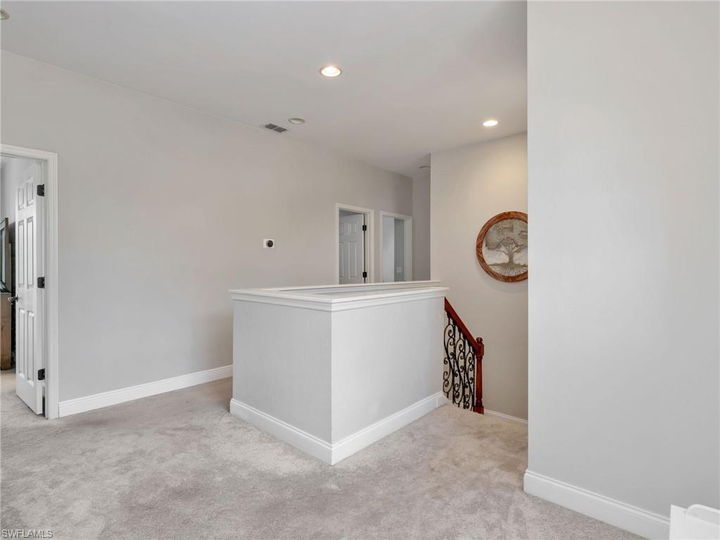 Carpeted landing featuring recessed lighting and light gray walls