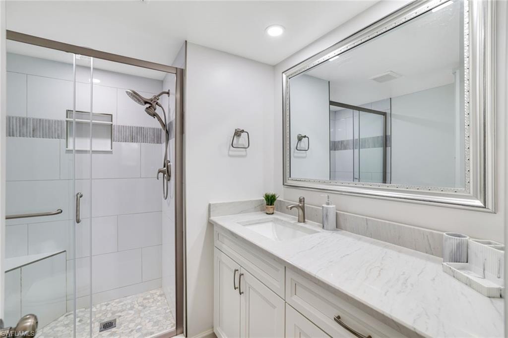 Bathroom with vanity, a shower stall, and recessed lighting
