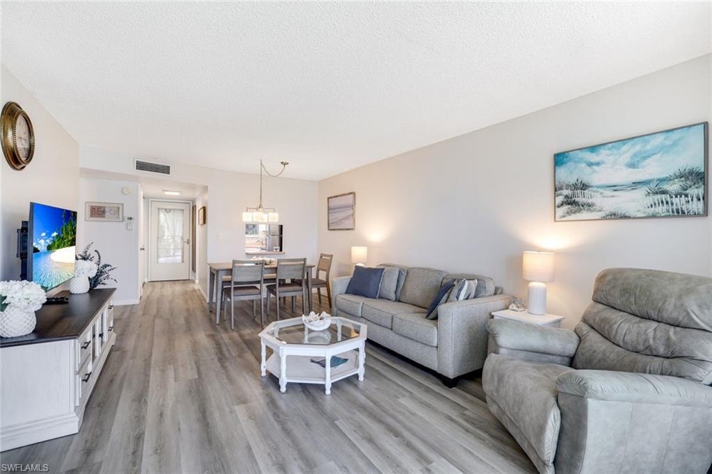 Living room with light wood-type flooring and a textured ceiling