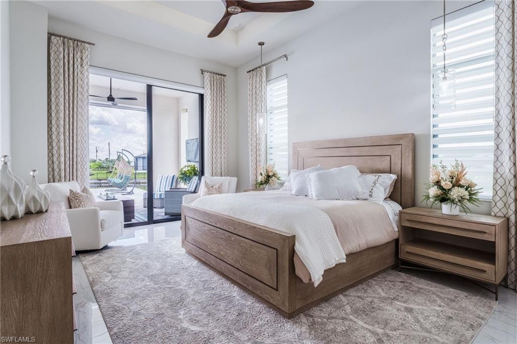 Primary expansive bedroom with direct access to an outdoor patio, featuring large sliding glass doors and white window treatments