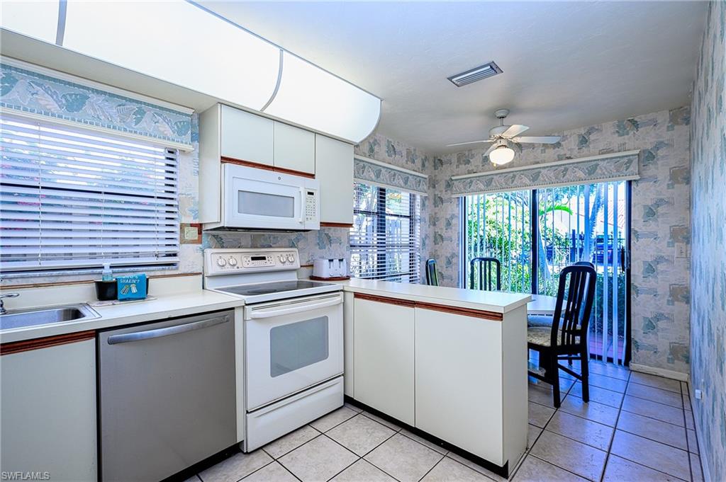 Kitchen featuring dishwasher, electric range, white cabinetry, and a healthy amount of sunlight