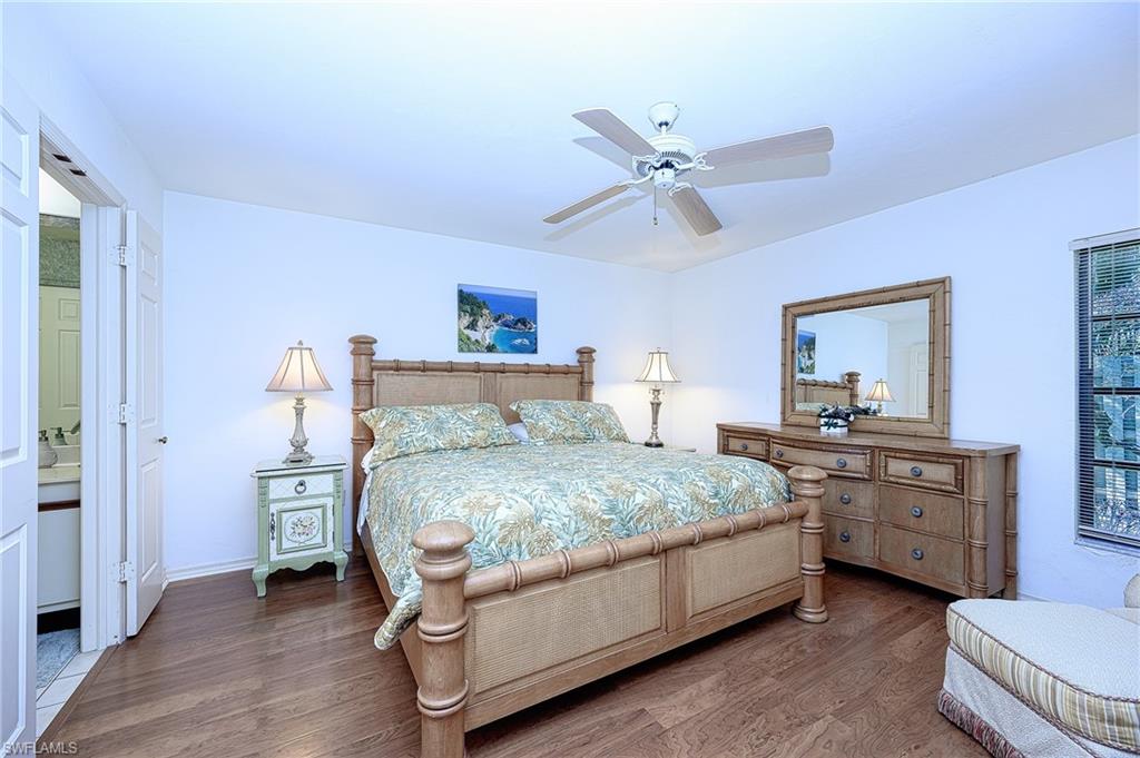 Bedroom with connected bathroom, ceiling fan, and dark wood-type flooring