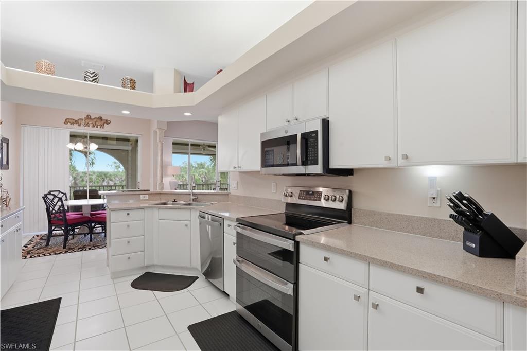Bright kitchen features stainless steel appliances.