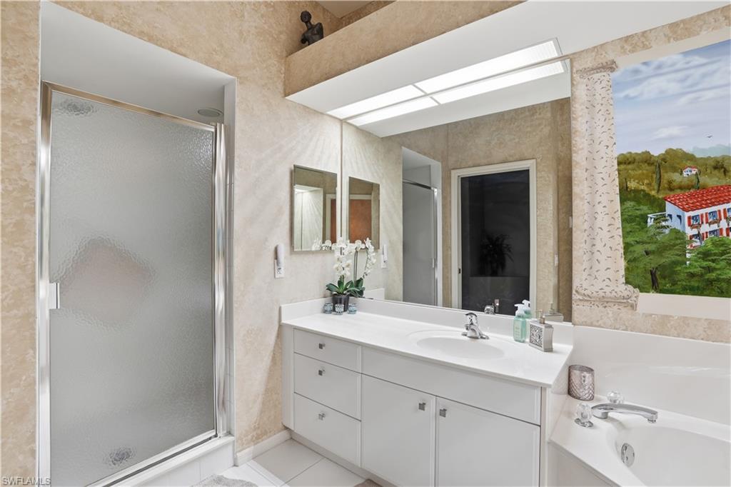 Primary bathroom features a large vanity, sperate shower, and soaking tub.