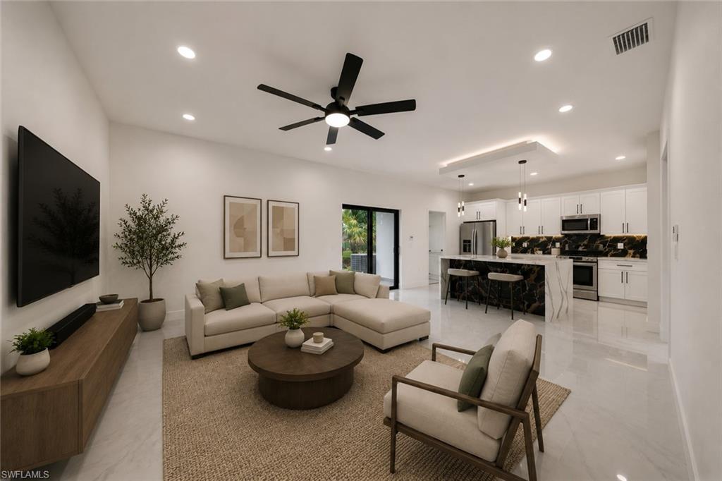 Open-concept living area with high ceilings and recessed lighting