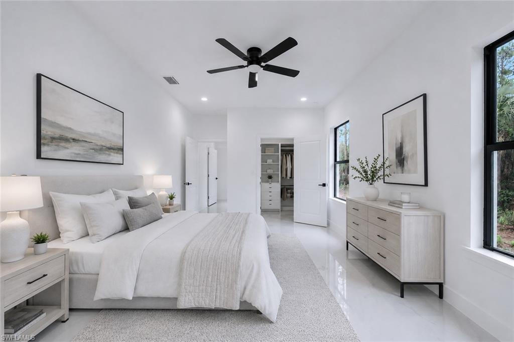 Bright room with white walls, polished flooring, and a black ceiling fan