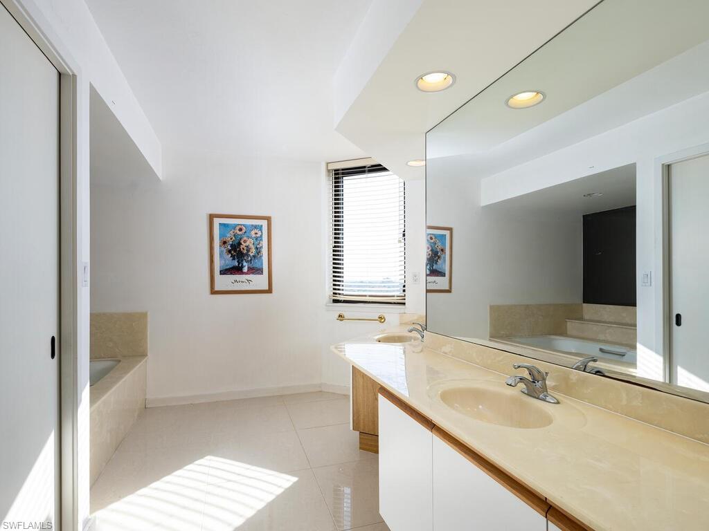 Bathroom featuring vanity, a bathing tub, and tile patterned flooring
