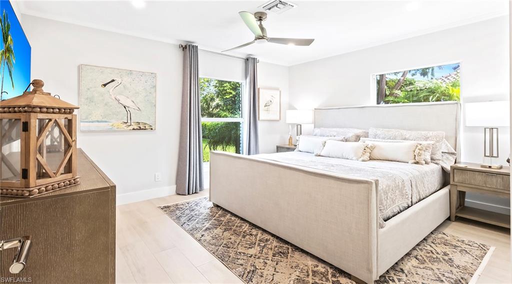 Bedroom featuring light wood-style flooring, a ceiling fan, multiple windows, and recessed lighting
