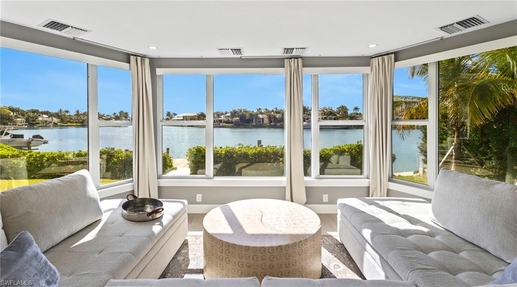 Sunroom featuring plenty of natural light and a water view