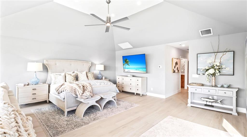 Bedroom with lofted ceiling, light wood-type flooring, and ceiling fan