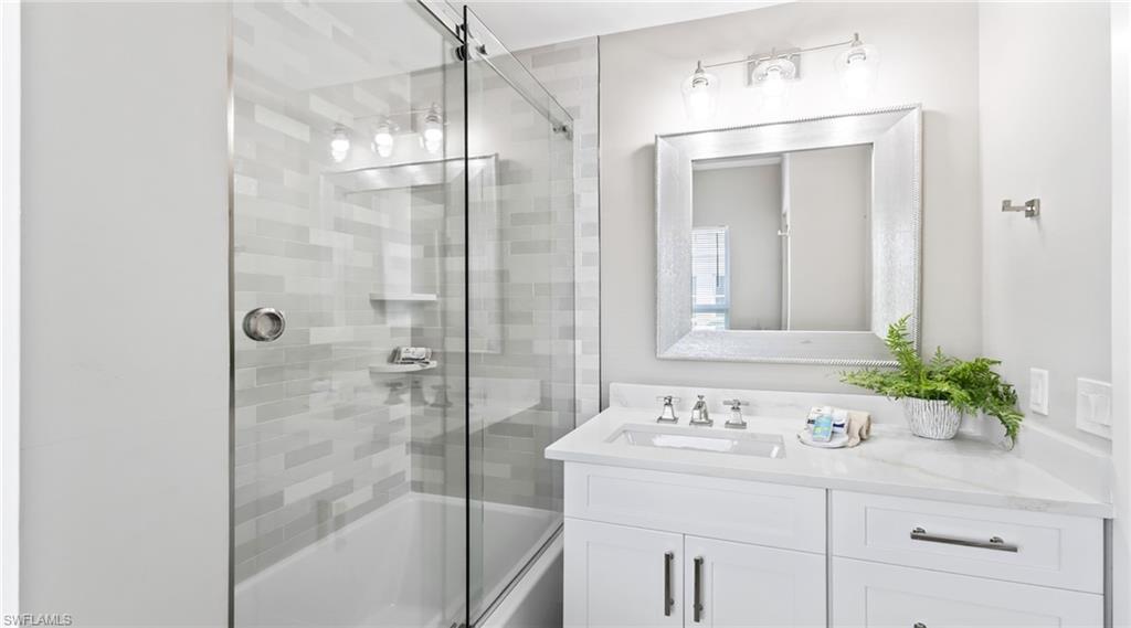 Full bath featuring bath / shower combo with glass door and vanity