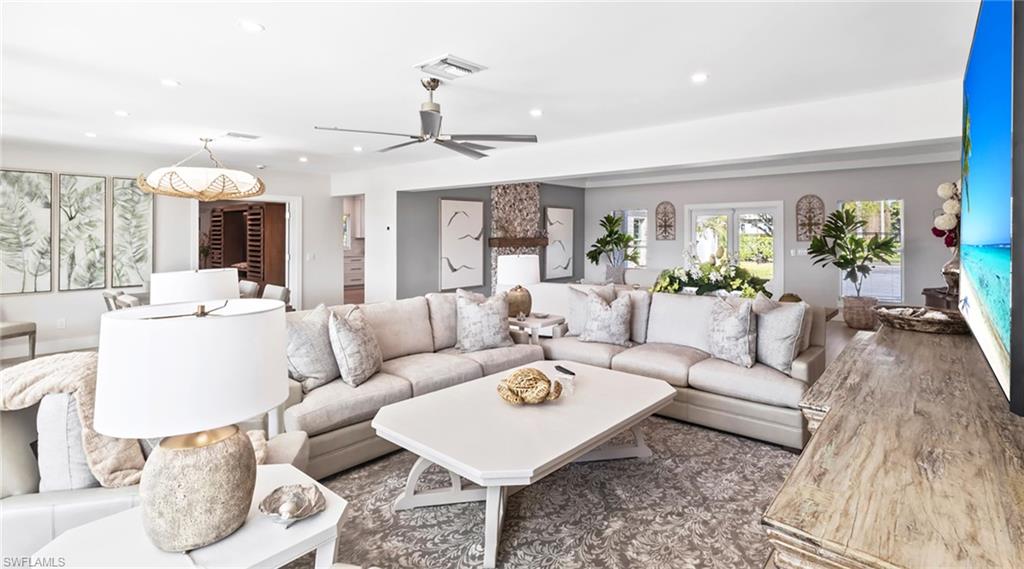 Living area with a ceiling fan, recessed lighting, and dark wood finished floors