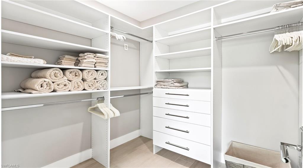Walk in closet with light wood-style flooring
