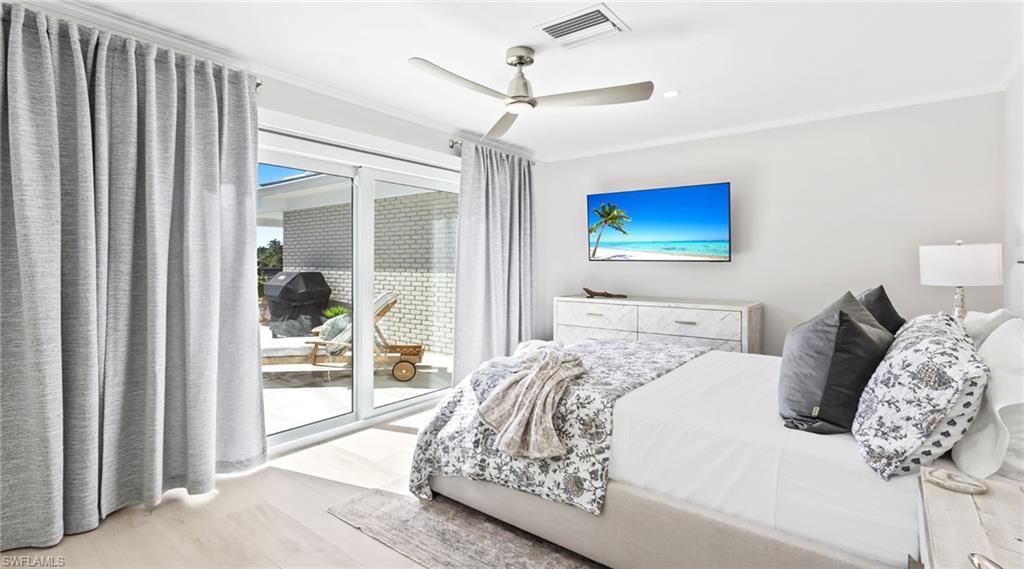 Bedroom featuring access to exterior, wood finished floors, and a ceiling fan