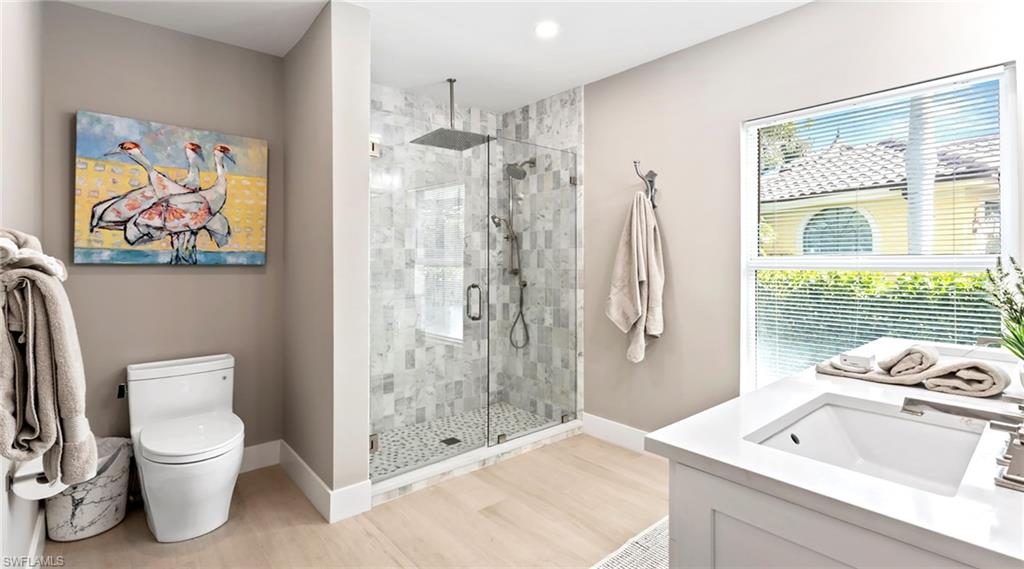 Bathroom featuring vanity, a stall shower, and light wood-style flooring