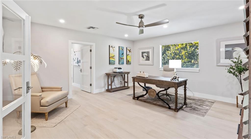 Office with light wood-type flooring, ceiling fan, and recessed lighting