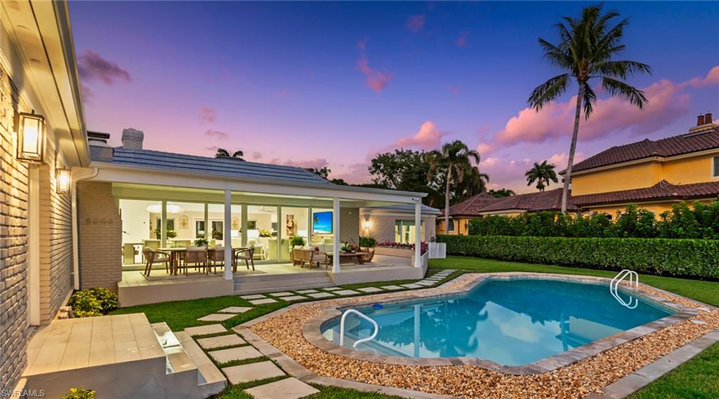 Pool at dusk with a patio area and outdoor lounge area
