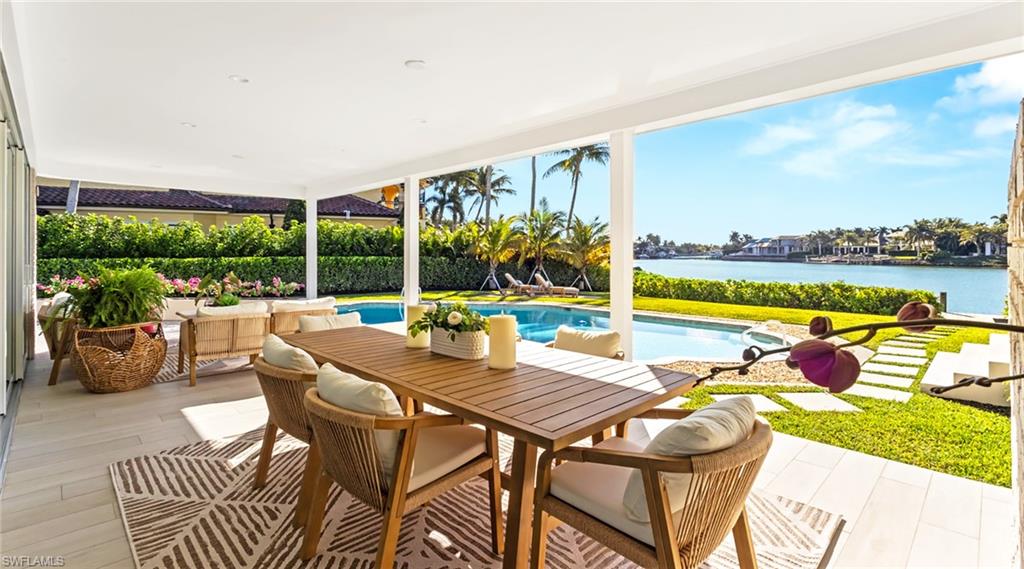 View of patio featuring an outdoor pool, outdoor dining space, and a water view