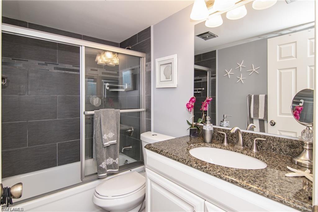 Updated bathroom with granite vanity and tiled tub/shower combination.