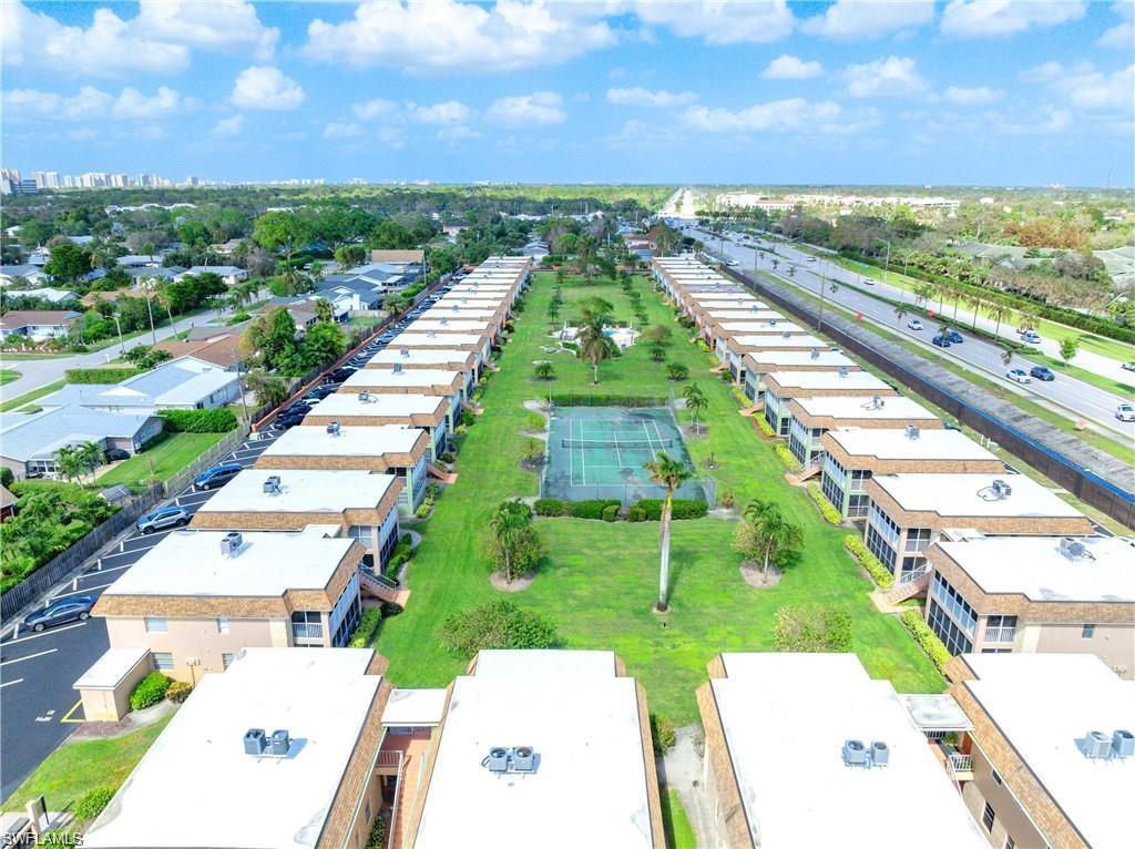 Aerial view highlighting the community layout, pool, tennis court, and landscaped grounds.