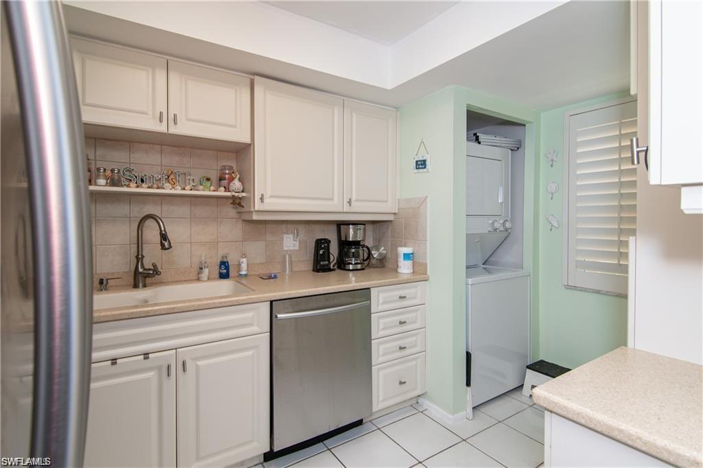 Kitchen features ample cabinetry, solid-surface counters, and in-unit laundry nearby.