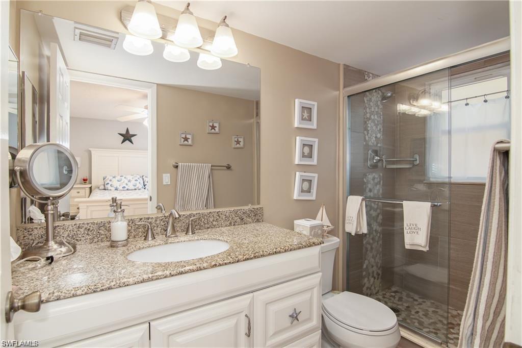Bathroom includes a granite vanity and tiled walk-in shower.