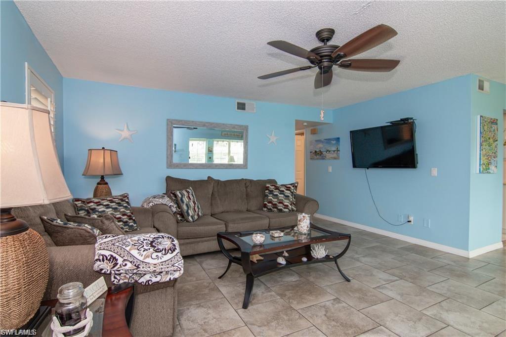 Open living area with tile flooring, large windows, and abundant natural light.