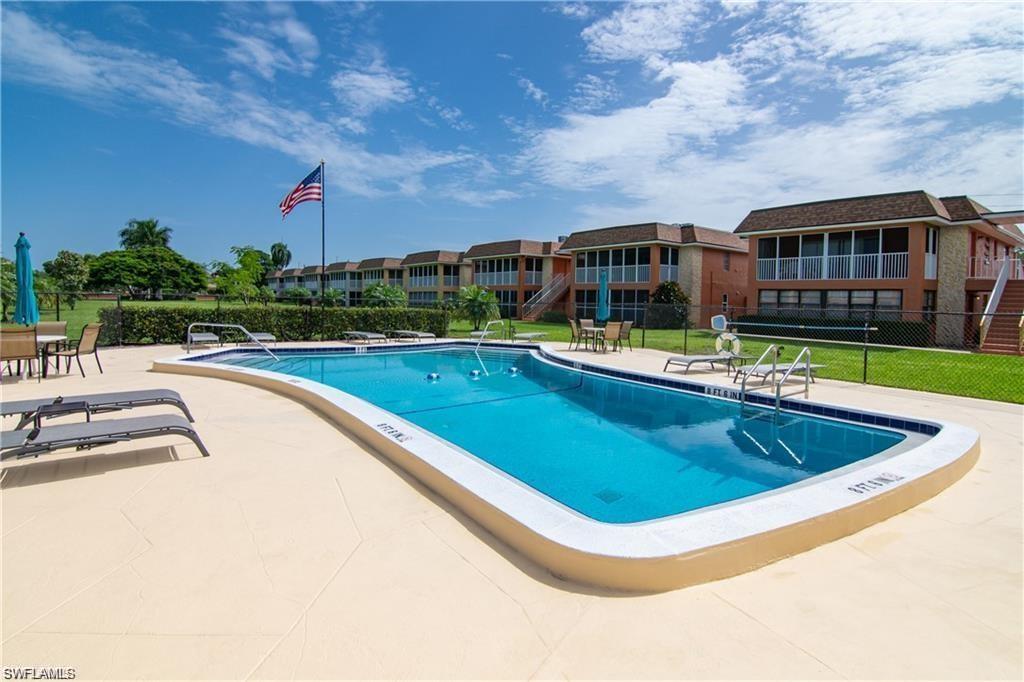 Community pool with sundeck, lounge chairs, and shaded seating.
