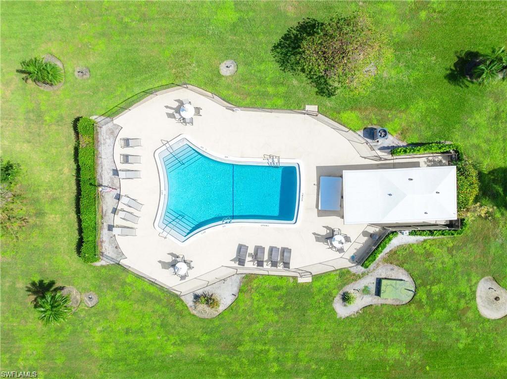 Aerial view of the community pool with surrounding sundeck and seating areas.swimming pool, surrounding concrete deck, and a fenced perimeter