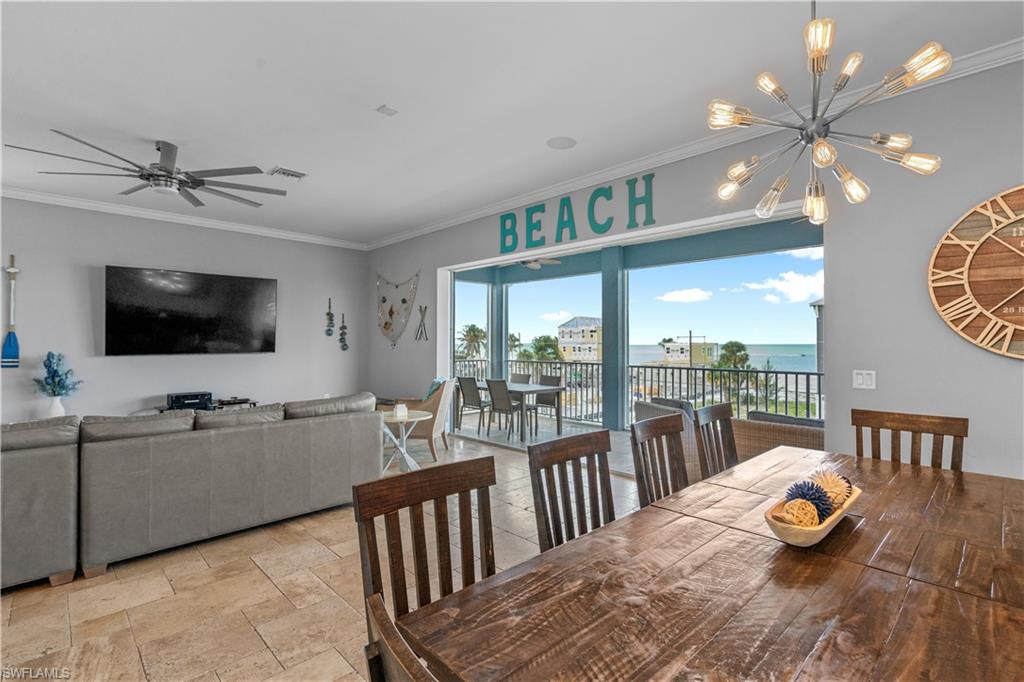 Open-concept living and dining area featuring tile flooring, a large wood dining table, and direct access to an exterior balcony