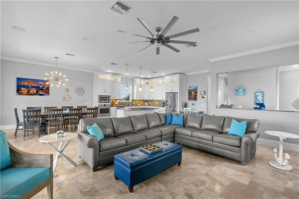 Open-concept living space featuring neutral tone flooring, a multi-blade ceiling fan, and recessed lighting