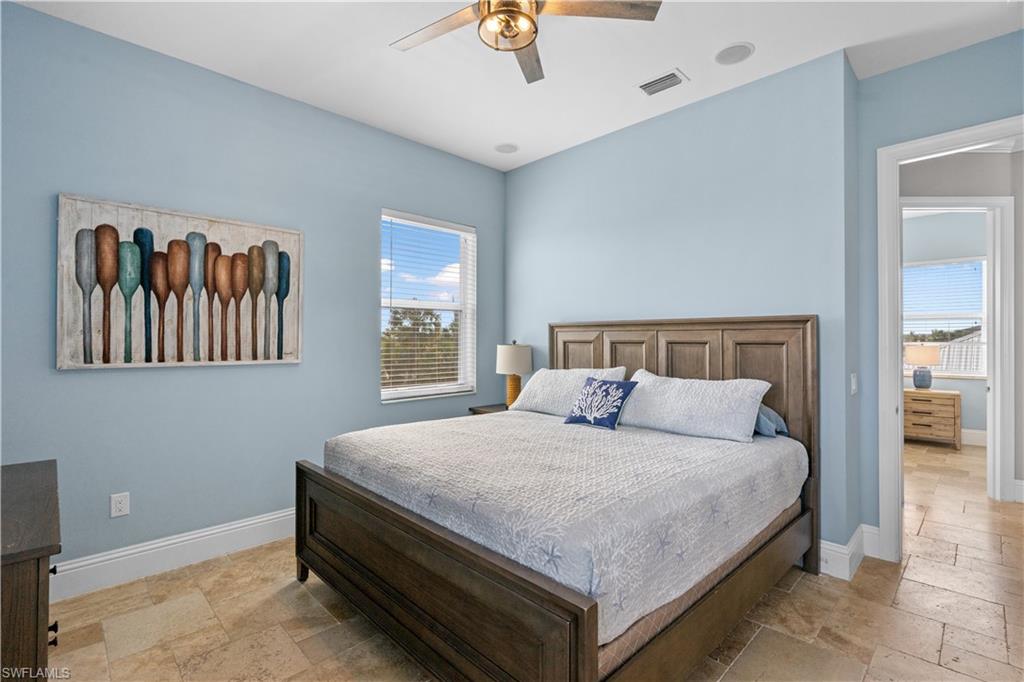 Recessed lighting, ceiling fan, and light blue walls complementing the tile flooring