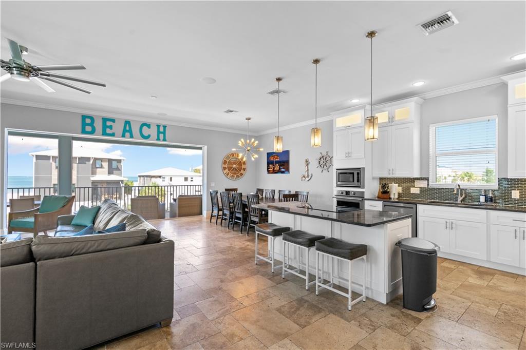 Open-concept living area featuring a large kitchen island with seating, a dining area, and expansive sliding glass doors