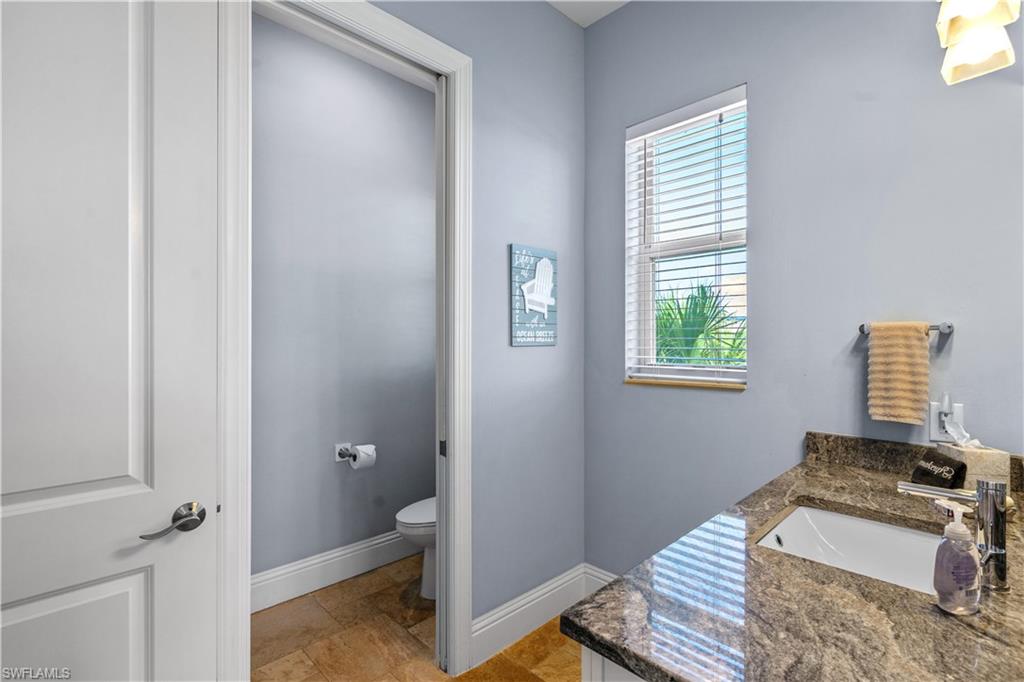 Bathroom vanity featuring a granite countertop with an undermount sink and private water closet