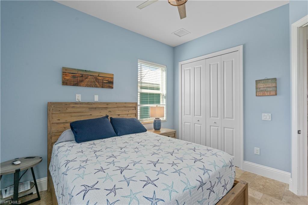 Bedroom featuring light blue walls, a ceiling fan, and tile flooring