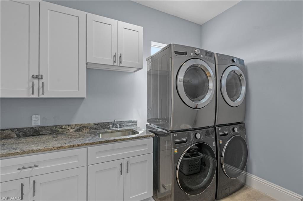 Laundry room with white shaker cabinetry, granite countertop, and stainless steel undermount sink