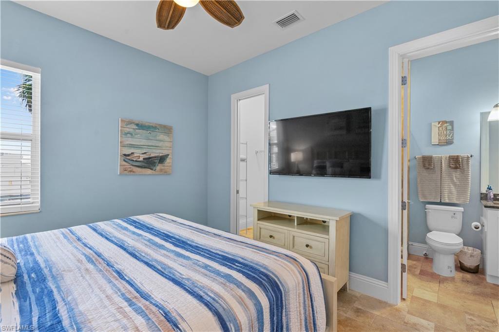 Bedroom featuring light blue walls, a ceiling fan, and a window with blinds