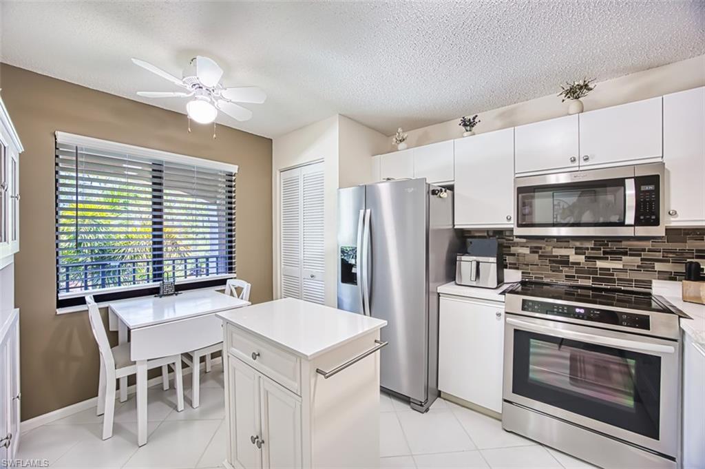 Kitchen with stainless steel appliances, a textured ceiling, backsplash, ceiling fan, and light countertops