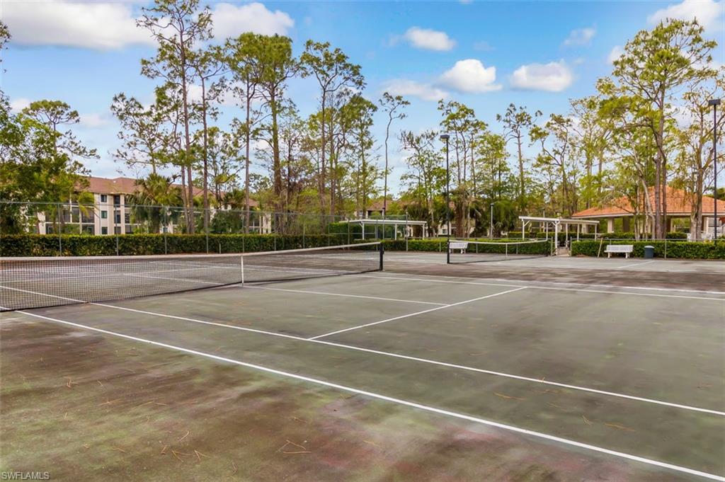 View of tennis court featuring fence and community basketball court