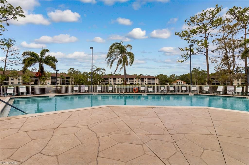 Community pool featuring fence and a patio area