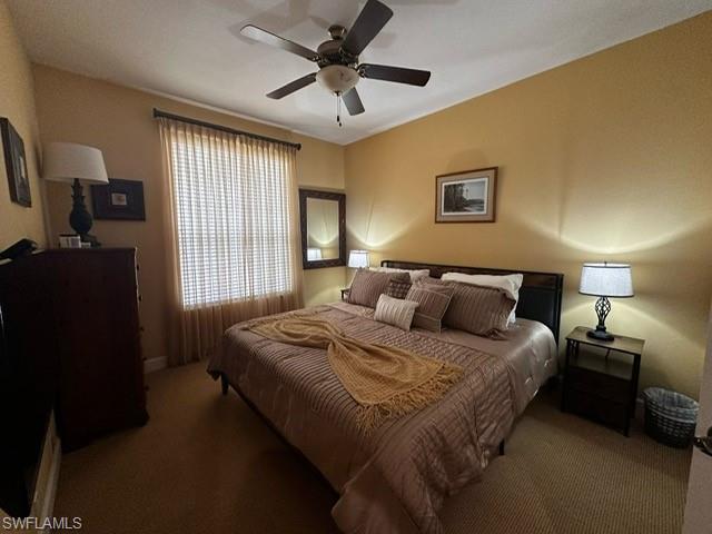 Carpeted bedroom featuring a ceiling fan and baseboards
