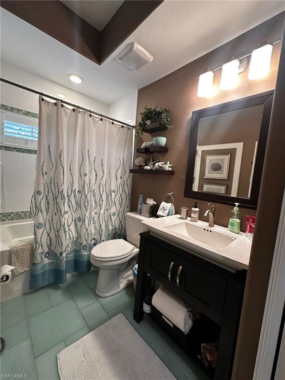 Full bathroom featuring tile patterned flooring, visible vents, toilet, vanity, and shower / bath combo with shower curtain