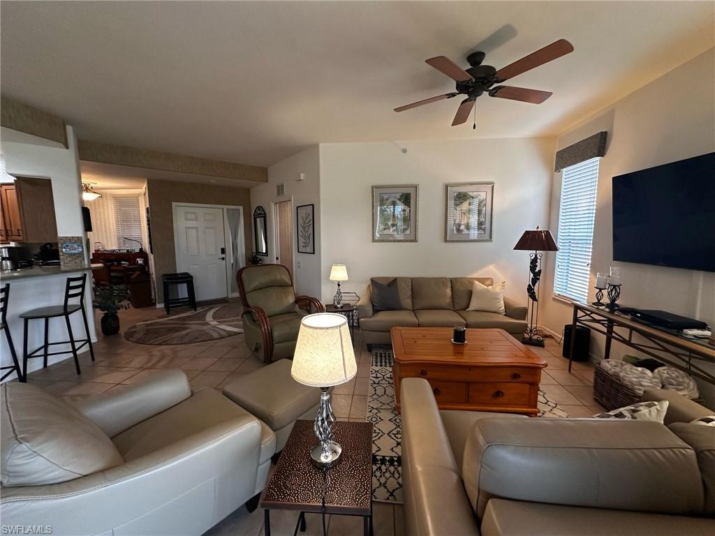 Living room featuring ceiling fan and light tile patterned floors