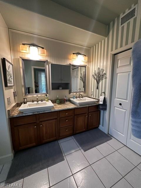 Full bath with tile patterned flooring, visible vents, a sink, and double vanity
