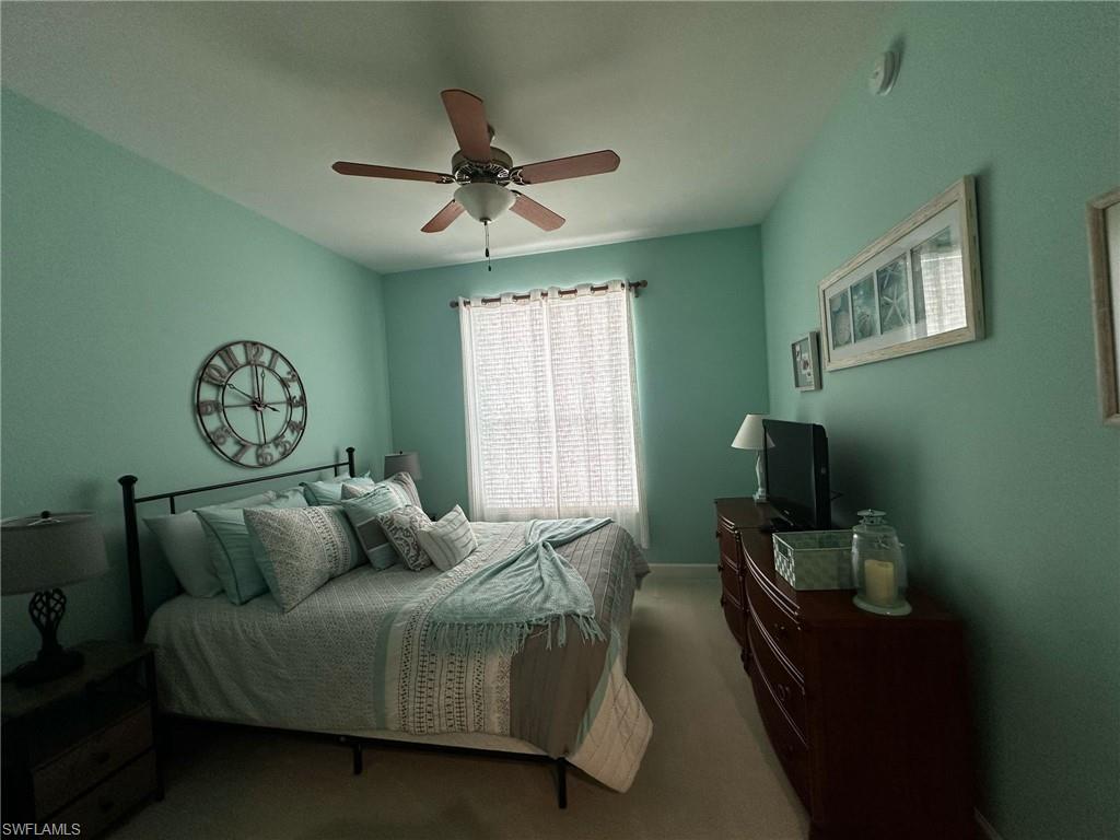 Bedroom featuring a ceiling fan and carpet