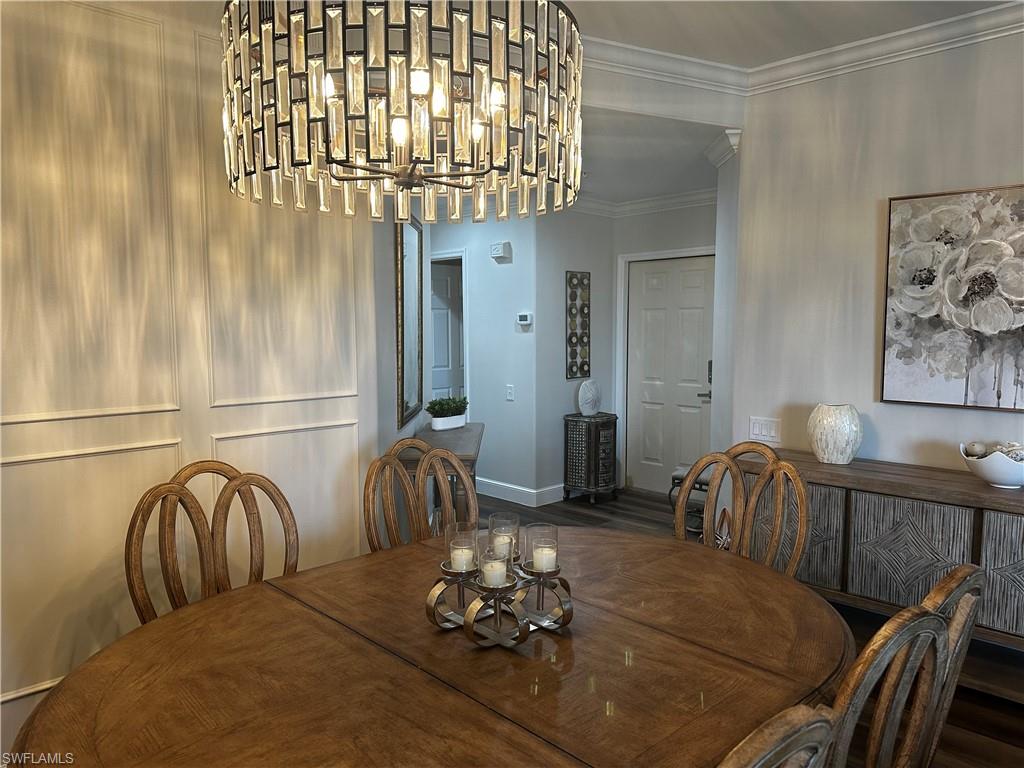Dining room featuring baseboards, ornamental molding, and a notable chandelier